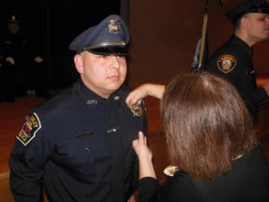 Anne Adam pins the Rowley Police Department badge on her son, Officer Robert Adams during his graduation from the Reading Police Academy this month.